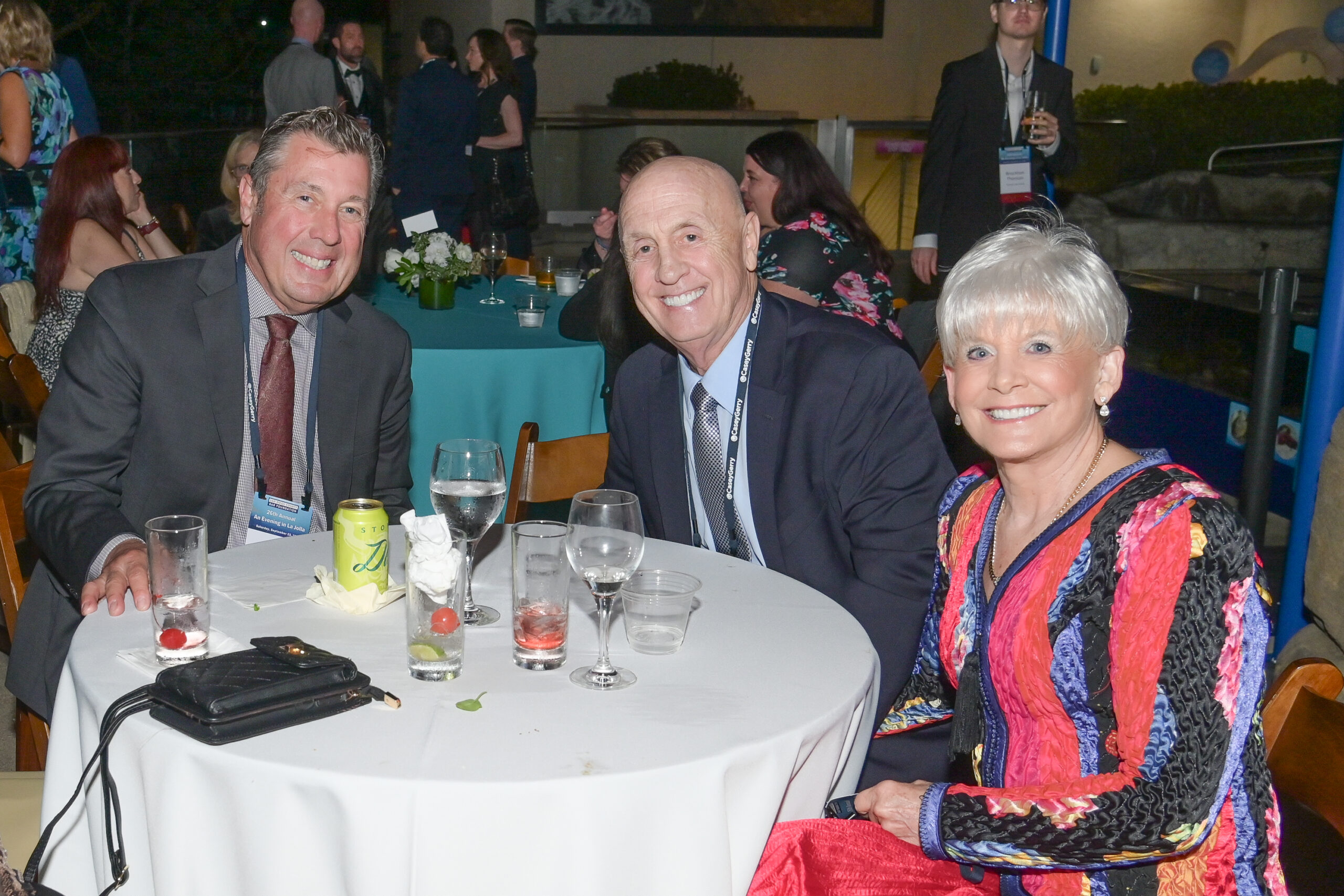 3 smiling attendees at a table at the Evening in La Jolla 2024 event.